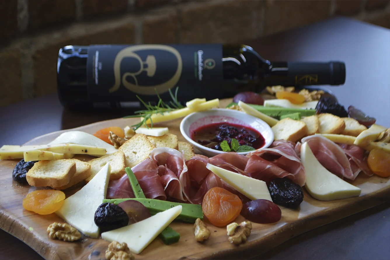Cheese and cured ham board with wine on the covered terrace overlooking Funchal